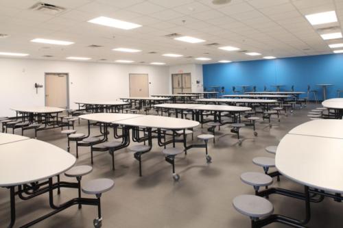 View of unique cafeteria tables with a bright blue wall in the background