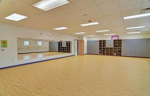 A dance classroom with mirrors lining nearly one entire wall