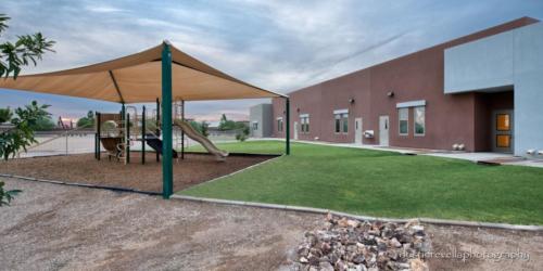 exterior of charter school with shaded playground area