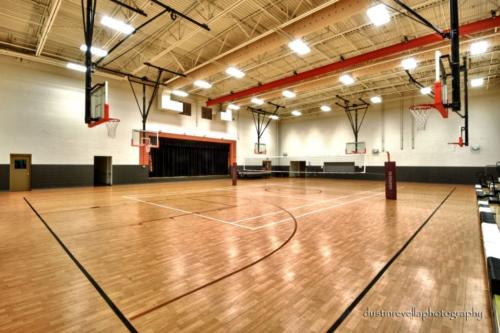 indoor gym with volleyball net and basketball hoops