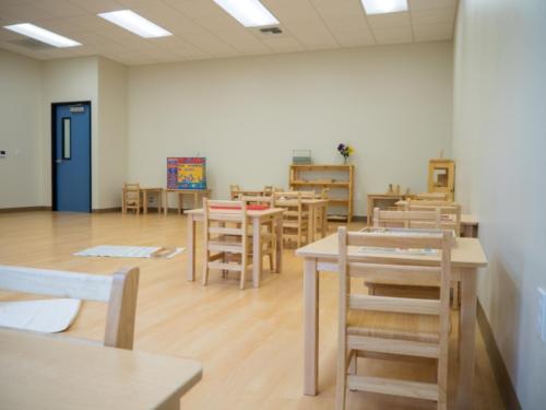 classroom with small wooden tables and chairs