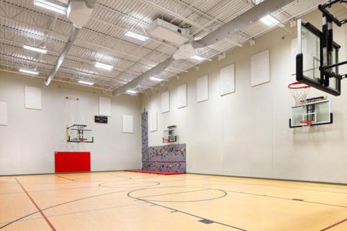 School gym with basketball courts and a climbing wall