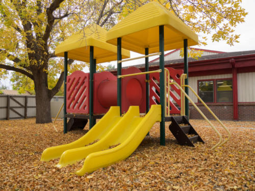 Playground equipment with fallen leaves covering the ground
