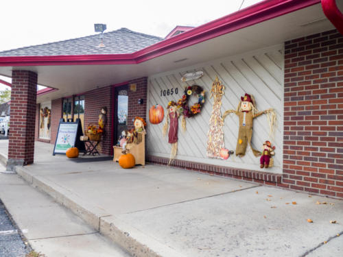 School exterior with scarecrows and other fall decorations