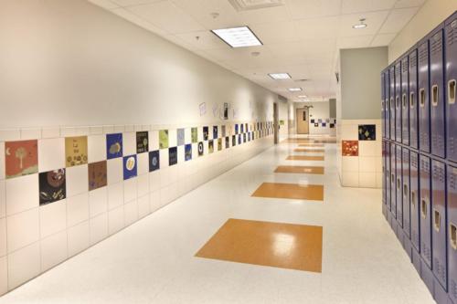 hallway with student art projects and lockers on the walls