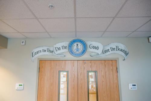 Mural over a door that reads "Learn the True, Do the Good, Love the Beautiful"