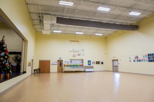 School gym with basketball hoops and a stage