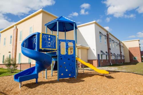 School exterior and blue playground equipment