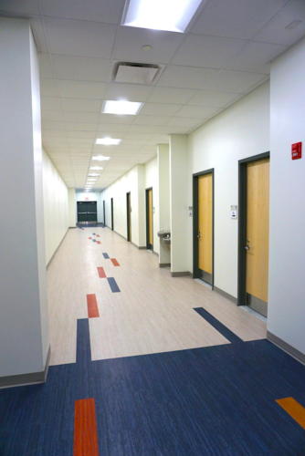 Hallway with sporadic blue and red floor tiles