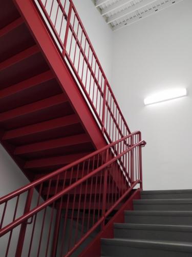 A stairwell with red guard rails