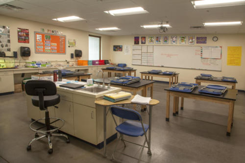 Science classroom with folding chairs placed on wooden tables