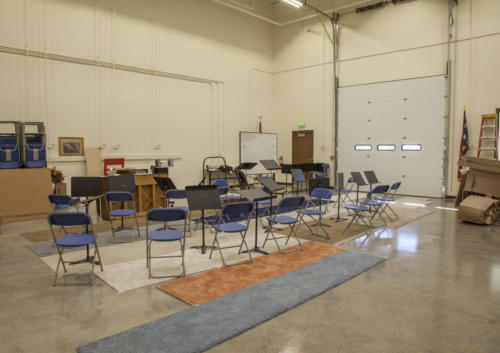 A large room with a piano set up for school band practice