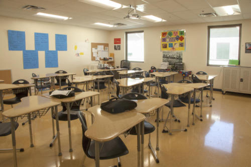 A classroom with triangular desks put together in pairs