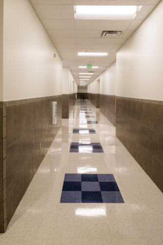 View down a long school hallway with a shiny tile floor