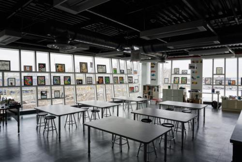 An art classroom with two glass window walls like a corner office