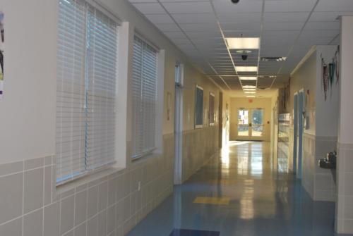 A hallway with blinds blocking the windows