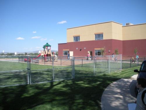 The school playground and basketball courts behind a fence