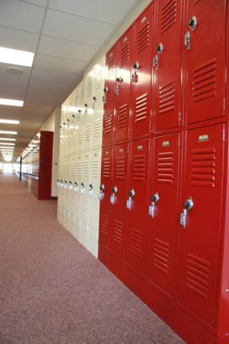 Red and white lockers line a school hallway