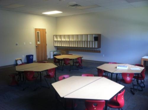 Hexagonal tables and red chairs sitting in a classroom