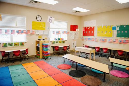 A colorful classroom with a rainbow-colored area rug