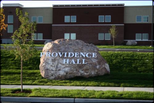 A boulder on the school property with the school name attached to it