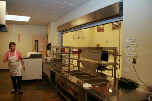The school kitchen with a worker looking at some equipment